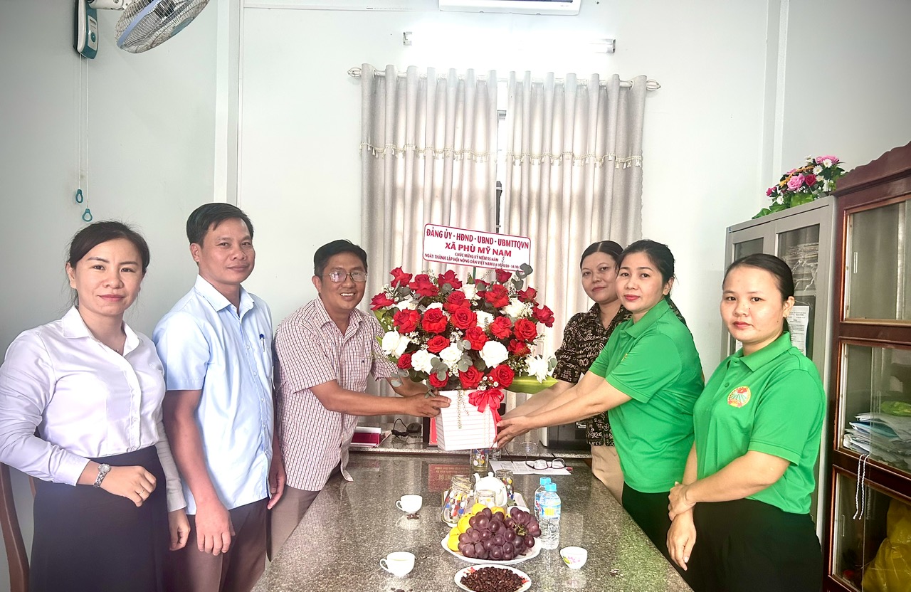 Đồng chí Phạm Thanh Bình - Phó Bí thư Thường trực Đảng ủy xã tặng hoa chúc mừng